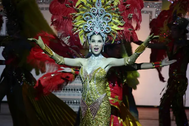 Performer in a gold revue costume on stage at Alcazar Cabaret, Pattaya