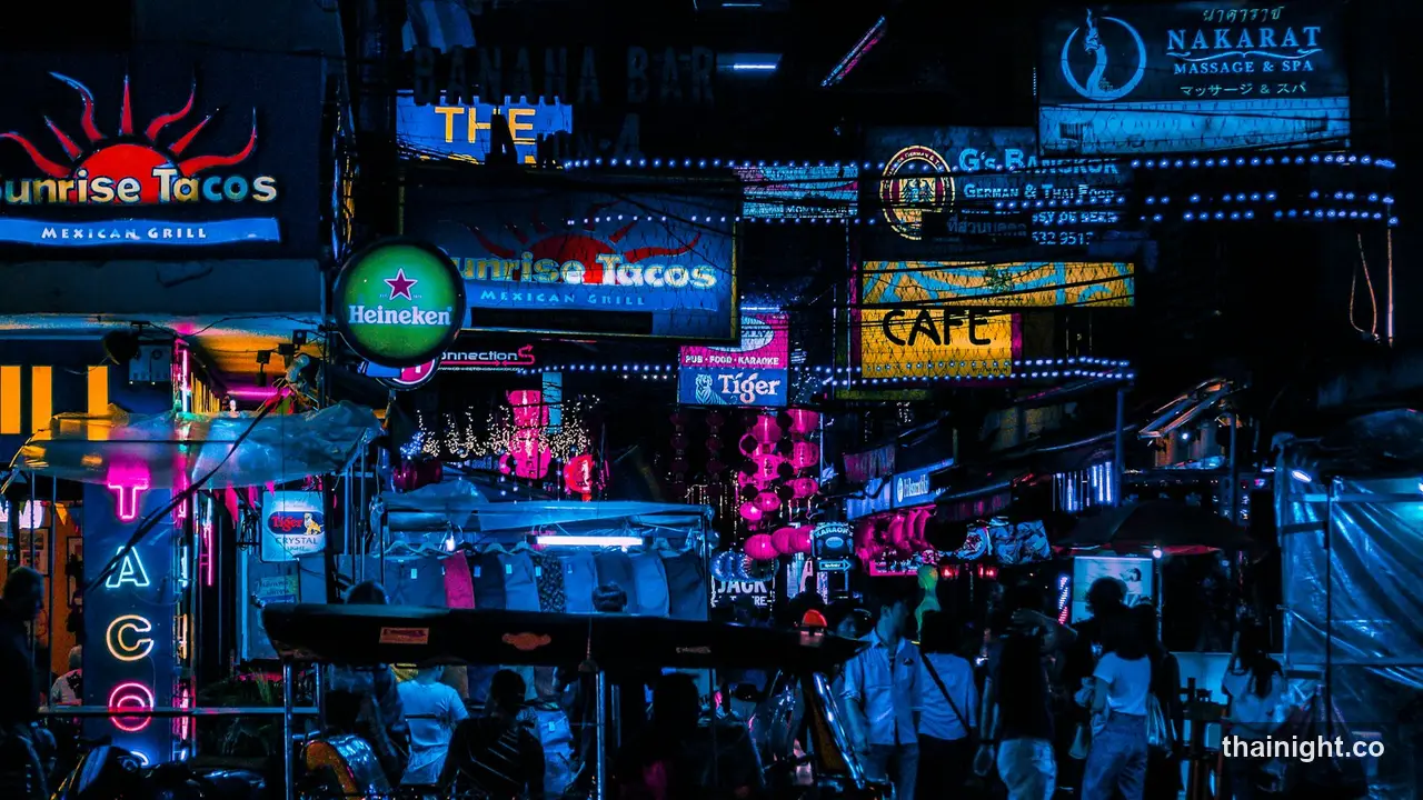 Neon bar and taco signs over the crowd on Khao San Road at night